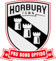 Horbury Town crest: three white castles on a black shield split by a zigzag line, over a red ribbon reading Pro Bono Oppido
